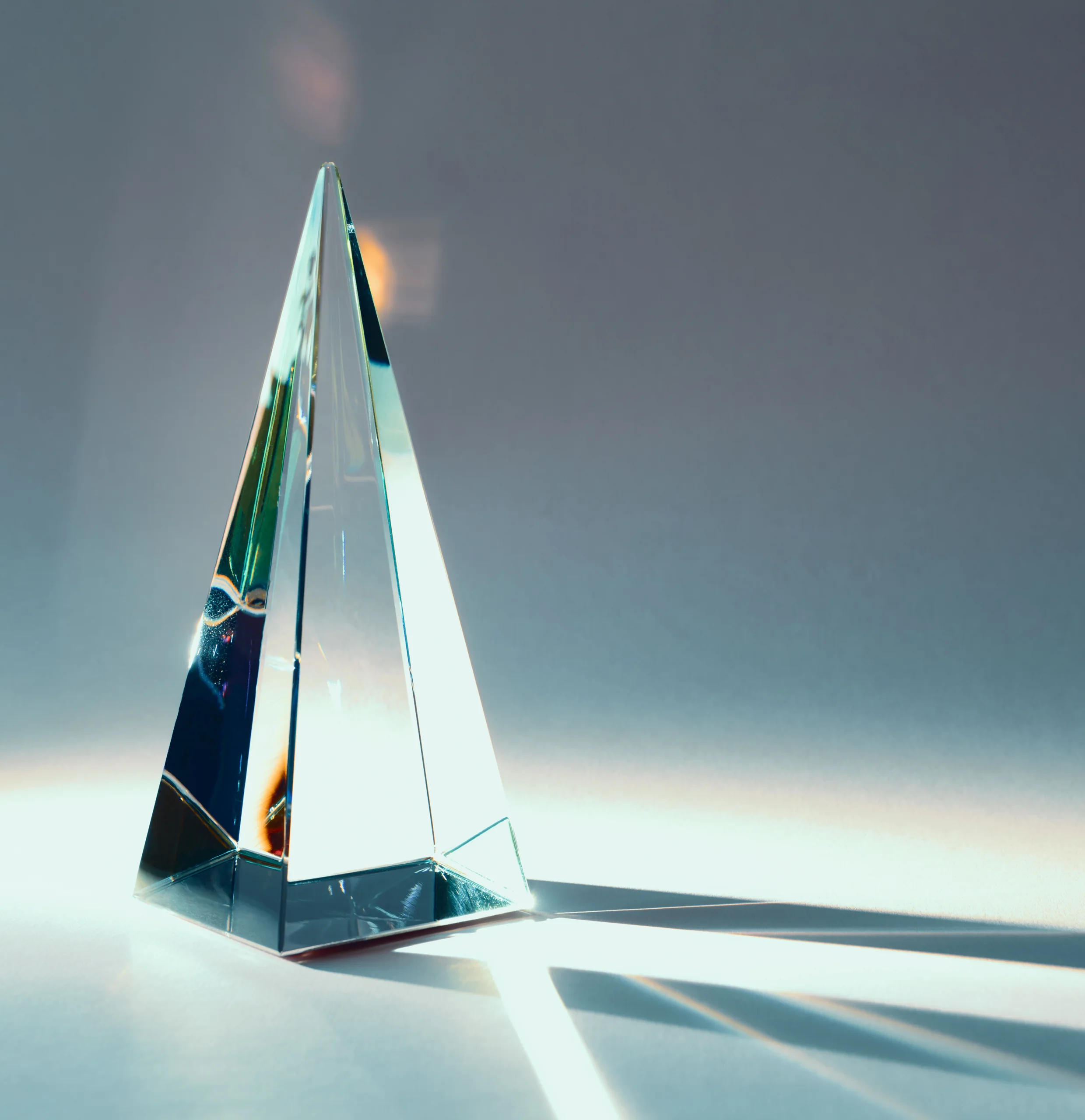 A crystal prism refracting light on a pale surface